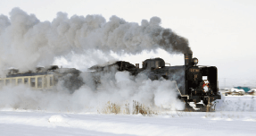 Una locomotora de vapor resoplando a través de campos cubiertos de nieve