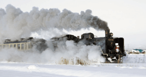 Uma locomotiva a vapor que atravessa os campos cobertos de neve.